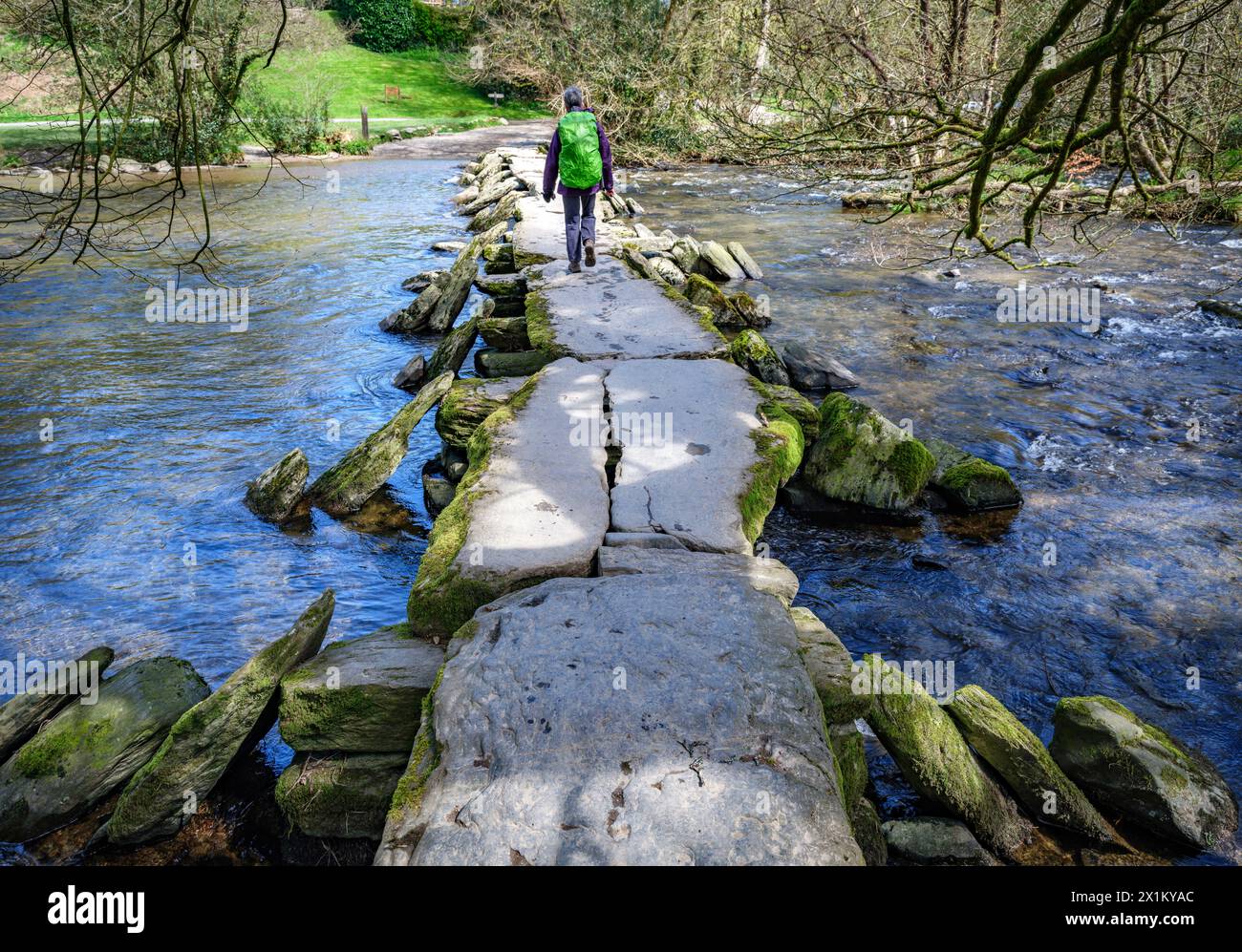 Walker con lo zaino che attraversa Tarr scala un ponte che attraversa il fiume Barle a Exmoor nel Somerset nel Regno Unito Foto Stock