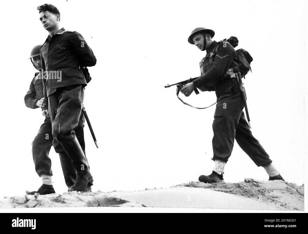 Un paracadutista "tedesco" catturato viene portato qui durante un'esercitazione militare della costa orientale condotta dall'esercito britannico. Foto Stock