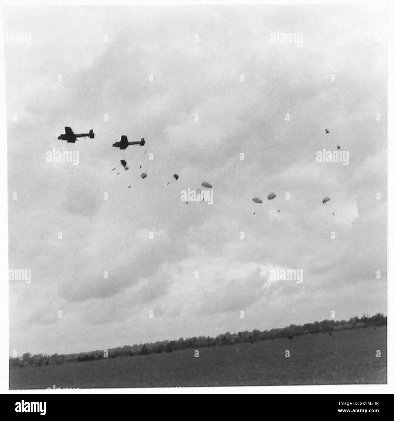 Le truppe di paracadutismo scendono durante le esercitazioni osservate dal re, illustrando le operazioni aviotrasportate e l'addestramento del personale militare. Foto Stock