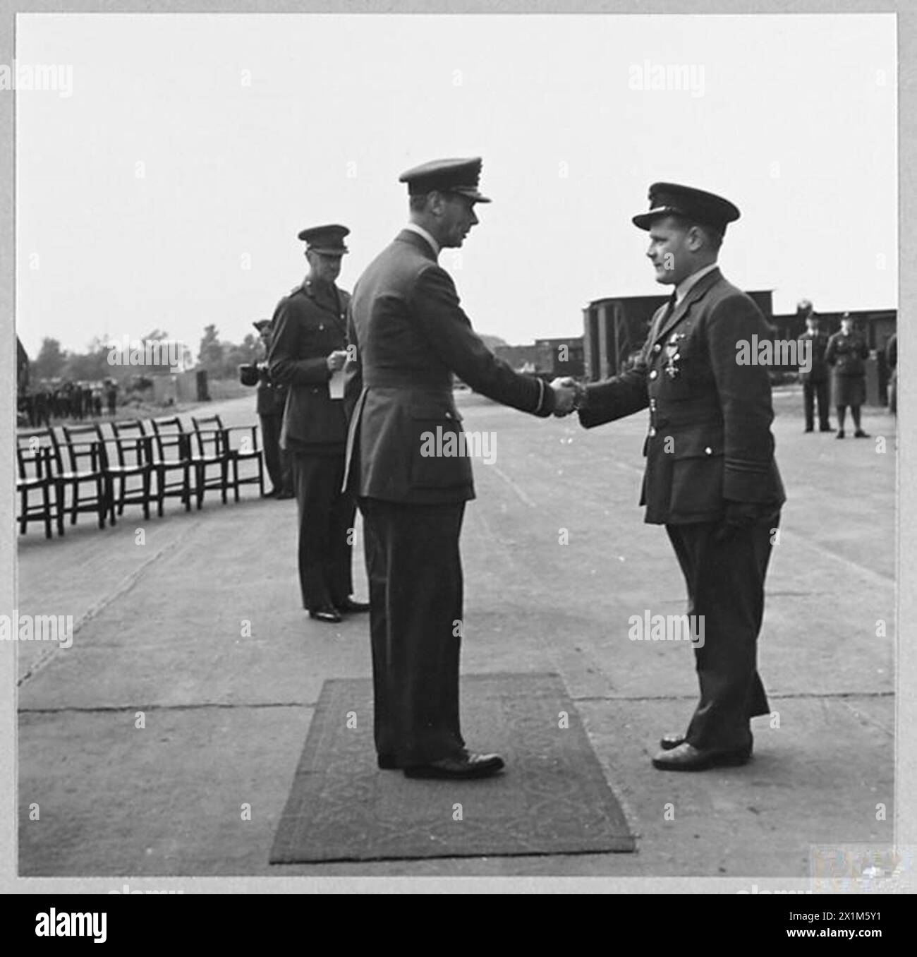 Nel 1944, re Giorgio vi si congratula con il Flight Lieutenant T.E.W. Allen della Royal Air Force dopo la presentazione del M.B.E. Foto Stock