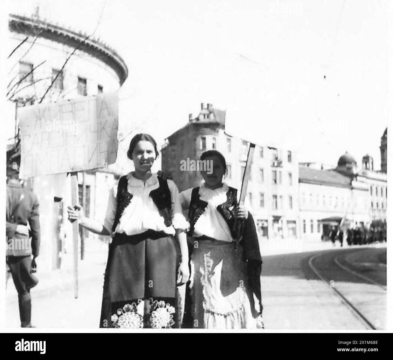 Le ragazze di Belgrado indossano costumi nazionali e portano striscioni durante le dimostrazioni pubbliche, osservate dal personale dell'esercito britannico. Foto Stock