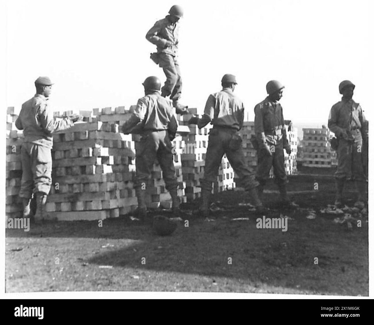 I soldati neri americani impilano traversine in cemento in un deposito di rifornimenti generali per la costruzione e la manutenzione di ferrovie, British Army. Foto Stock