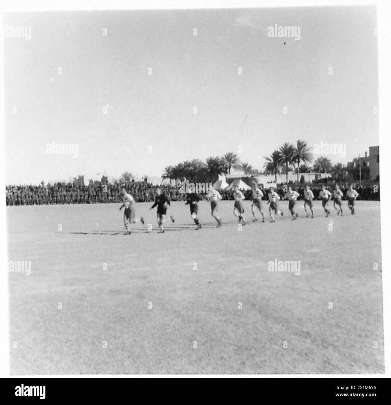 Le squadre di calcio dell'esercito polacco e britannico giocano una partita a Baghdad nel 1942-1943, con i giocatori polacchi che sconfiggono i britannici per 4-0. Tra gli spettatori di rilievo figurano figure militari e politiche. Foto Stock
