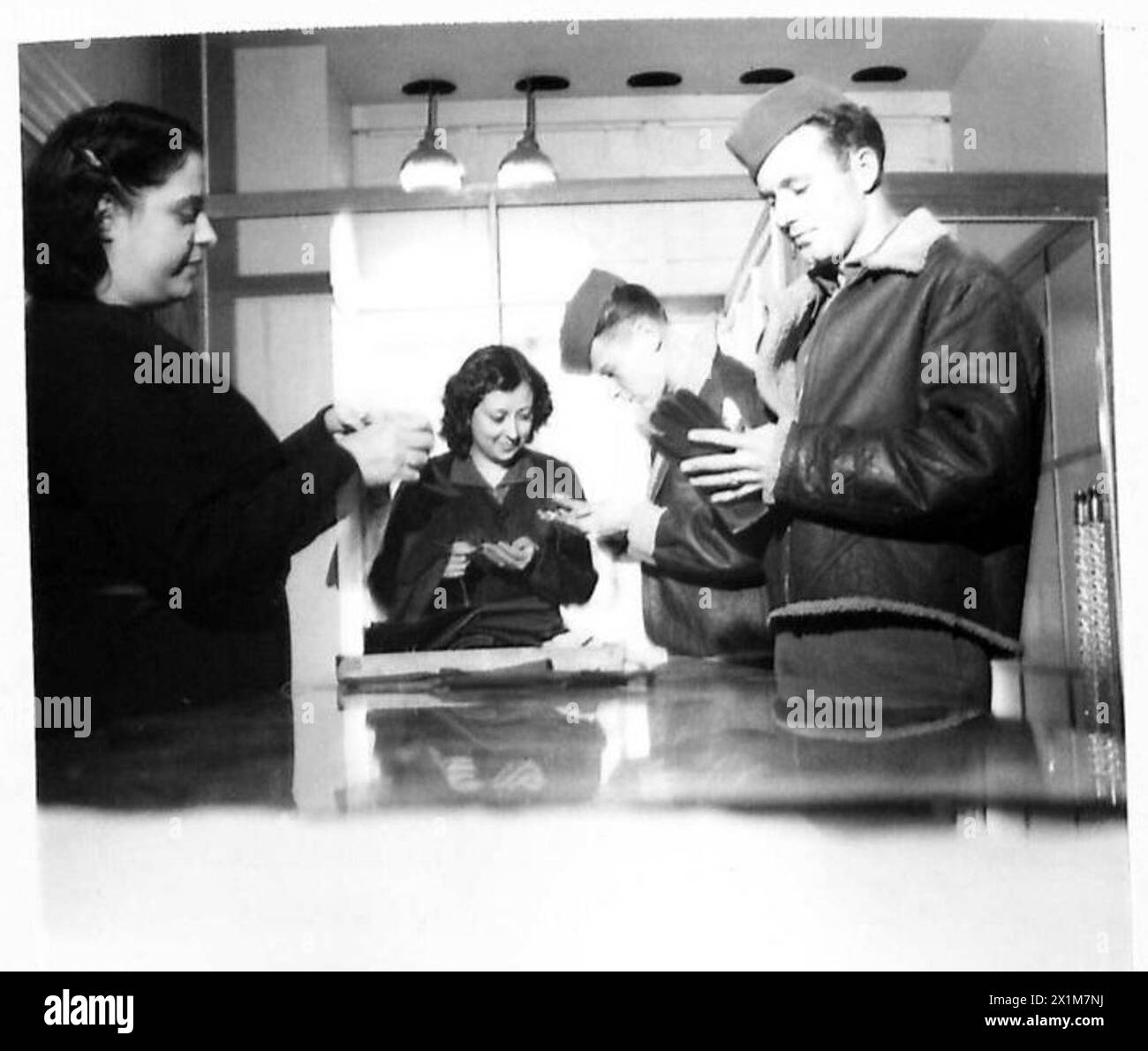 I soldati americani nella Napoli occupata dagli Alleati stanno facendo acquisti di guanti in un negozio locale, coinvolgendo i negozianti italiani durante la loro presenza in città. Foto Stock