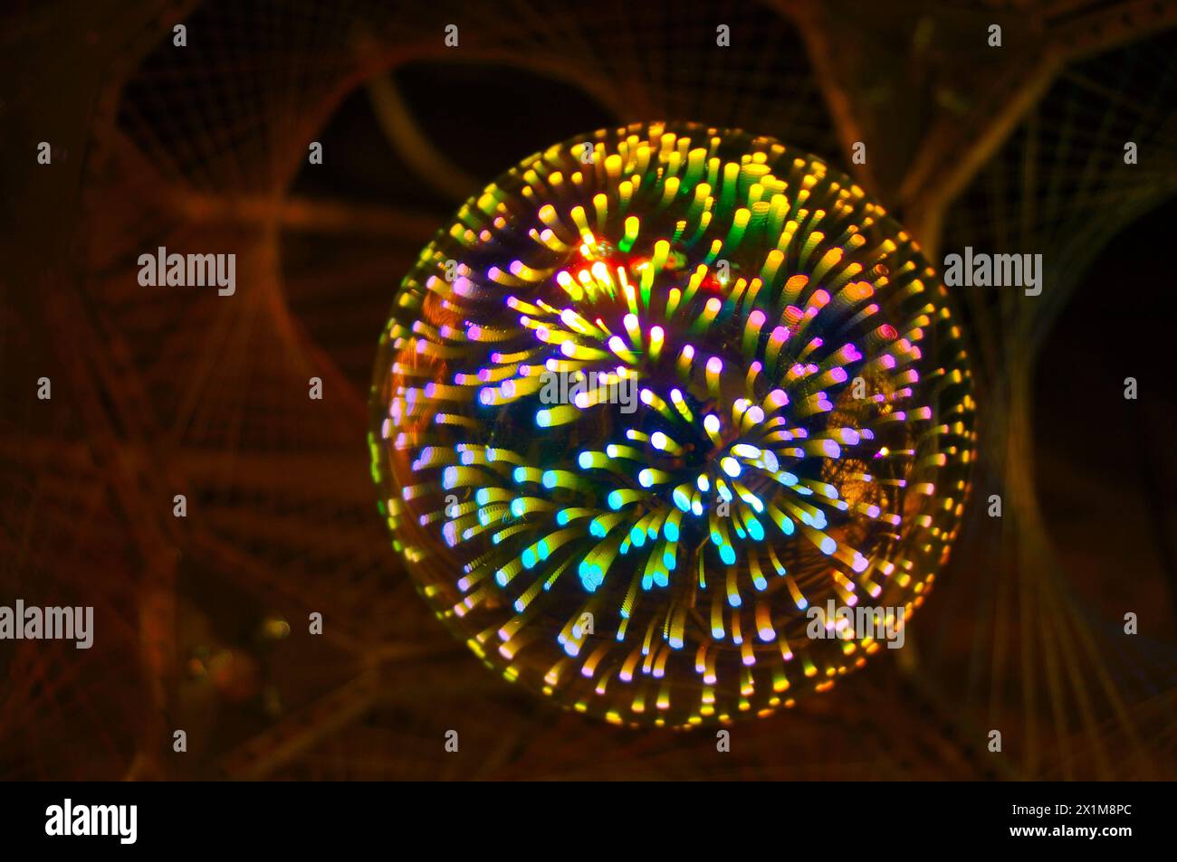 Una lampada colorata a forma di sfera è appesa al soffitto Foto Stock