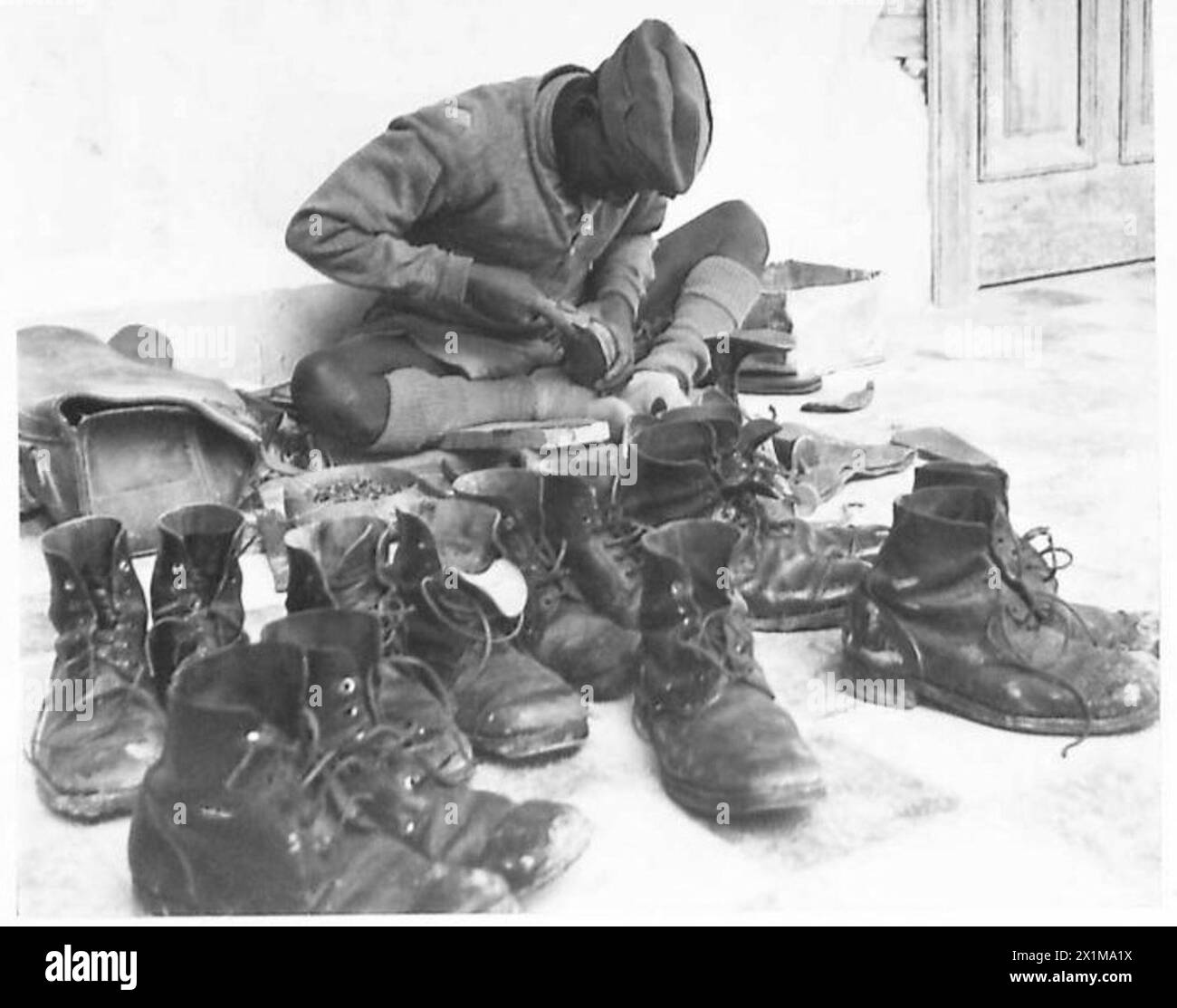 Un riparatore di stivali Sepoy a Cipro lavora in modo efficiente su più paia di stivali, mantenendo qualità e velocità, British Army. Foto Stock