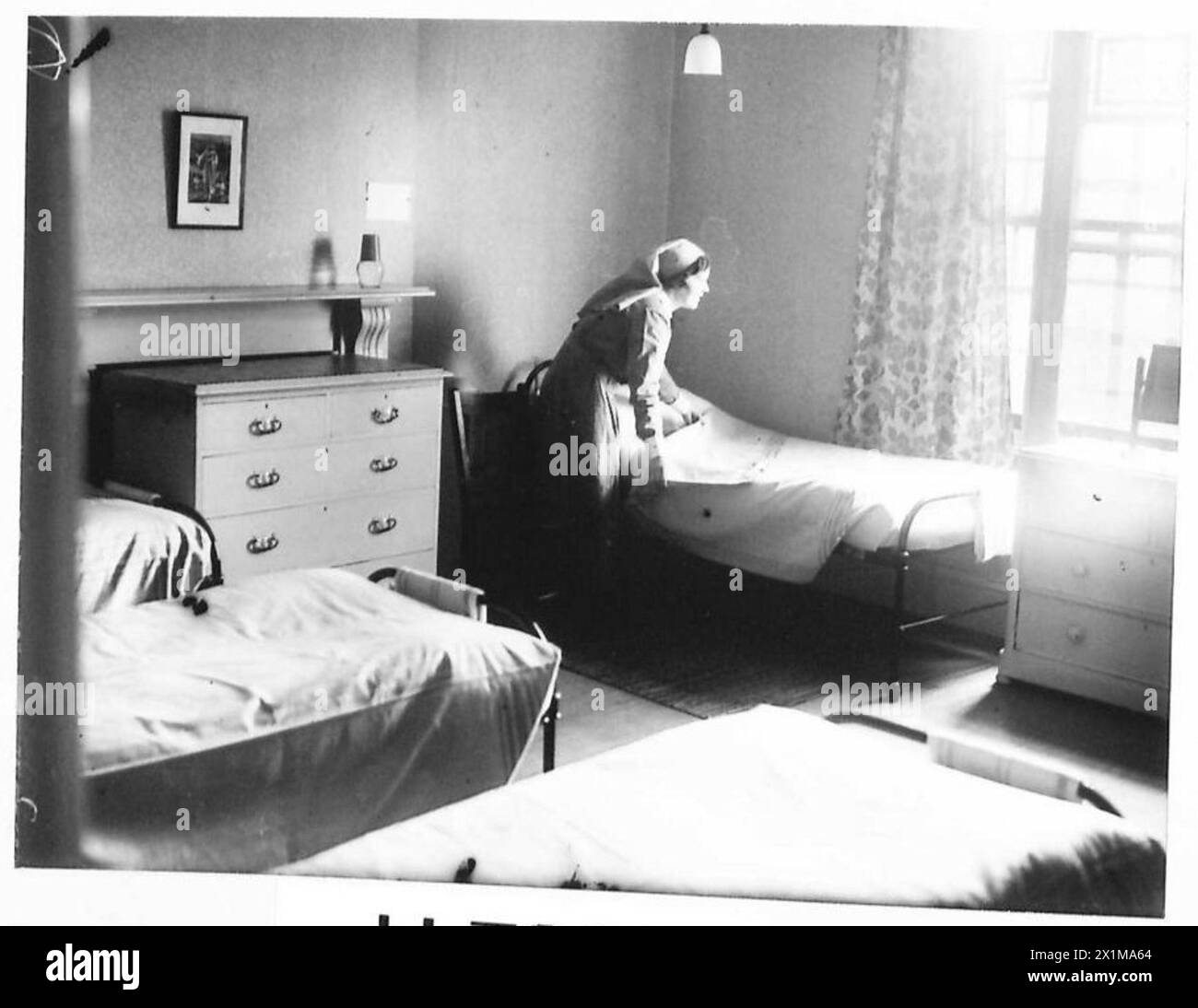 Una camera da letto all'interno di un ostello fornito per le mogli dei soldati dall'esercito britannico, che illustra le sistemazioni e le strutture domestiche. Foto Stock