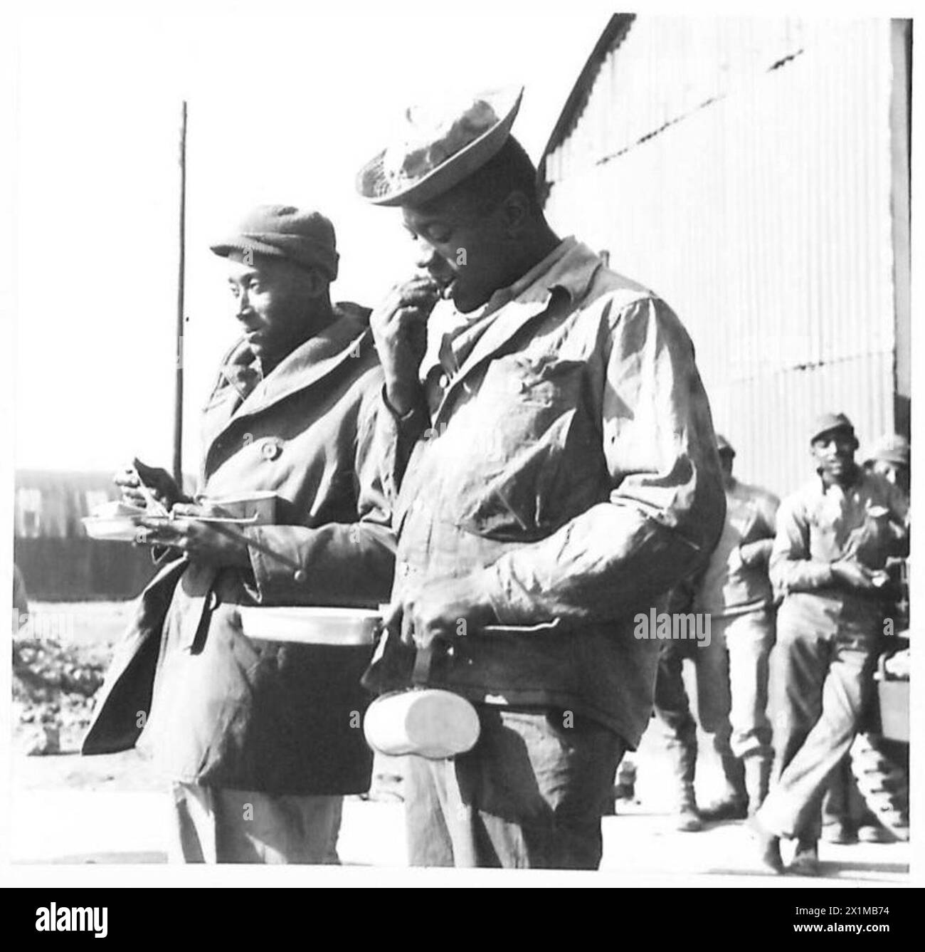 I soldati neri americani mangiano il loro pasto di mezzogiorno mentre lavorano in un deposito di rifornimenti generali per i negozi e le attrezzature americane, il British Army. Foto Stock
