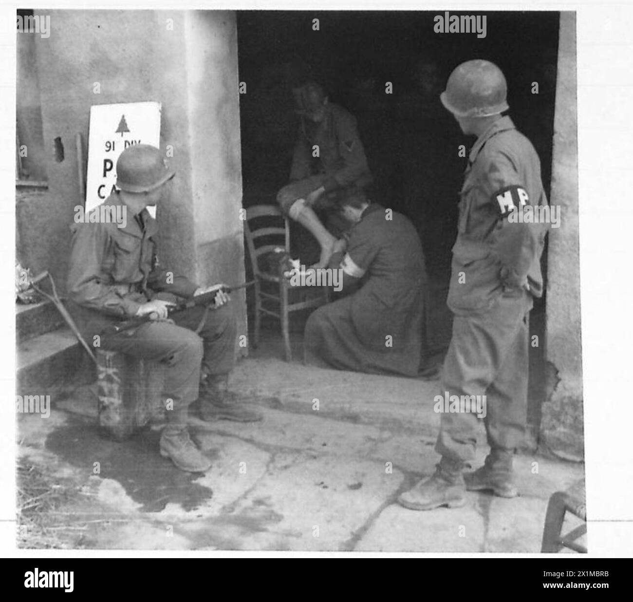 Il personale della Croce Rossa tedesca fornisce assistenza medica ai prigionieri di guerra feriti all'interno di una gabbia di prigionieri di guerra prima di trasferirli al Quinta Armata durante le campagne dell'esercito britannico in Nord Africa, Sicilia, Italia, Balcani e Austria, 1942-1946. Foto Stock
