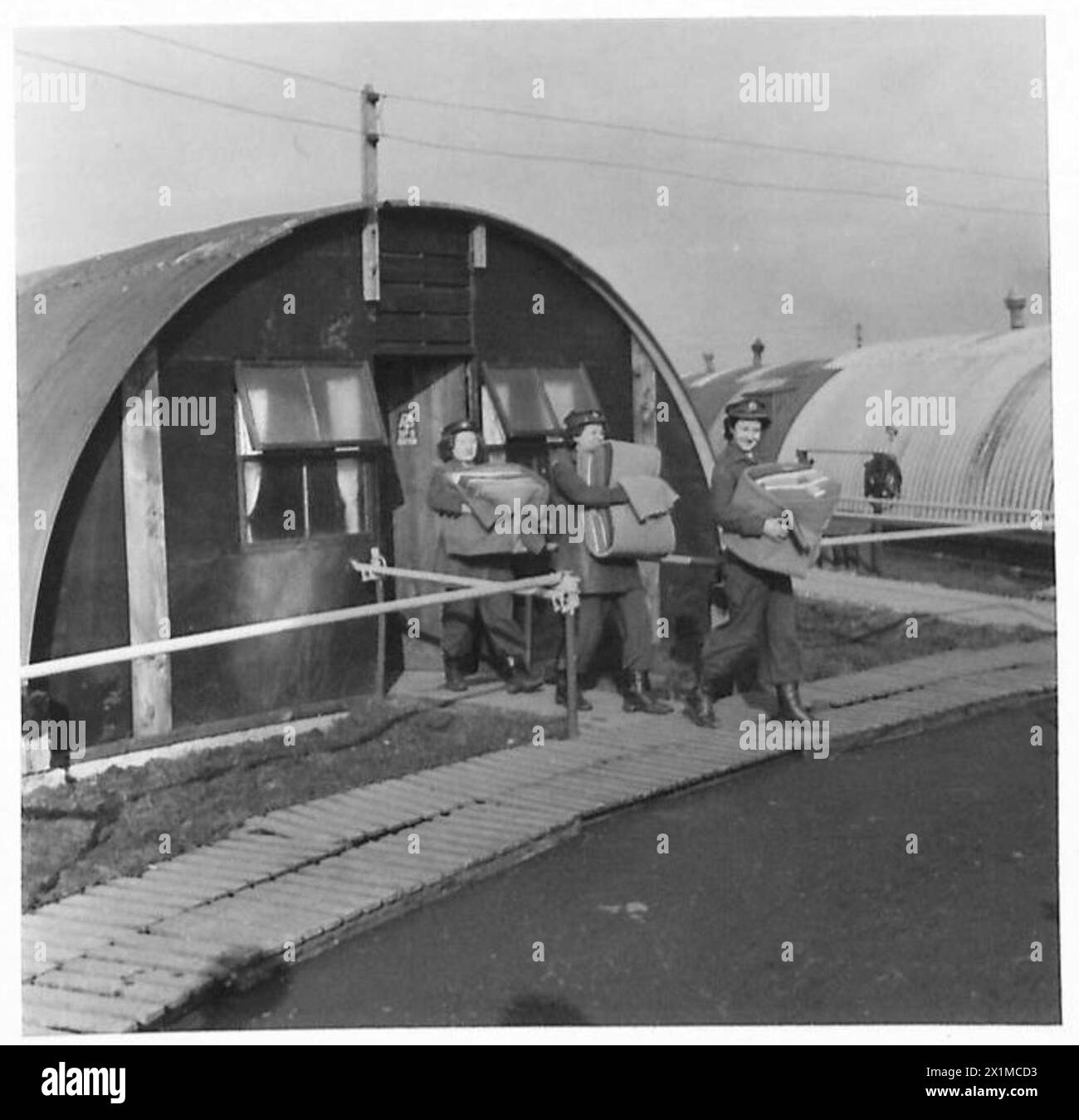 I membri dell'Auxiliary Territorial Service (A.T.S.) di una batteria mista antiaerea sono ritratti fuori dai loro nuovi quartieri sulla costa orientale dell'Inghilterra durante le operazioni dell'esercito britannico. Foto Stock