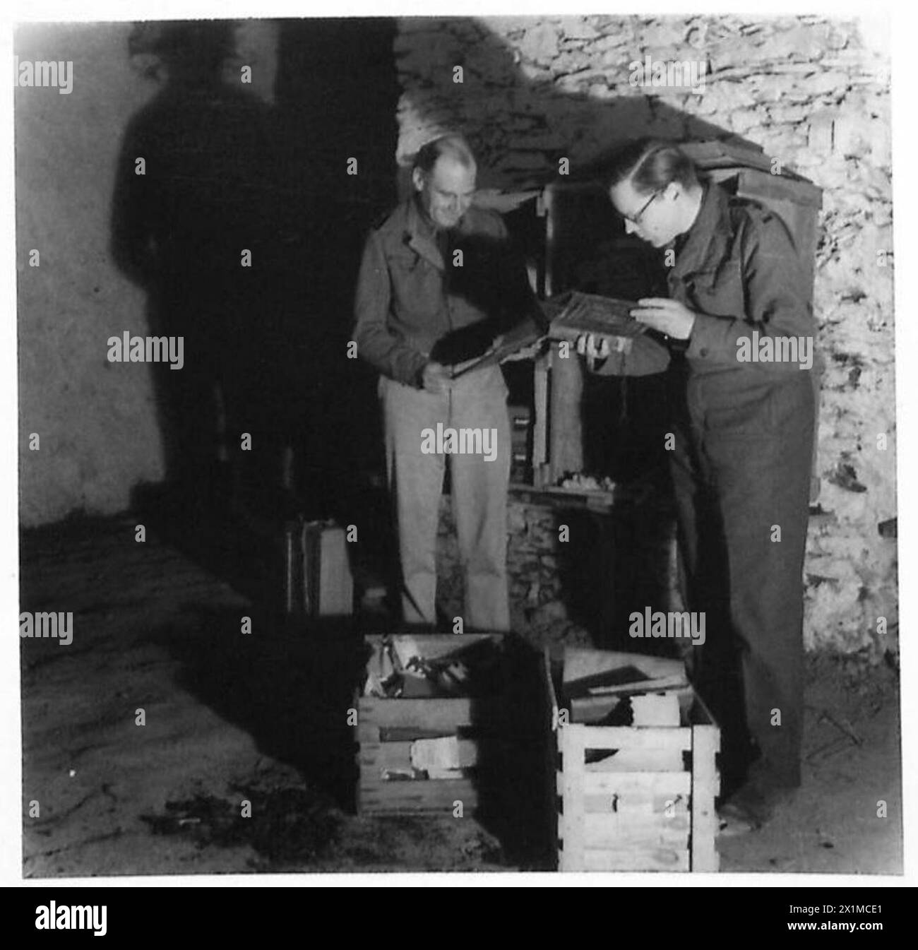 Il capitano E. Croft-Murray del British Museum e il capitano Humphrey-Brooke del Public Records Office ispezionano i libri saccheggiati dai nazisti scoperti dall'esercito britannico. Foto Stock