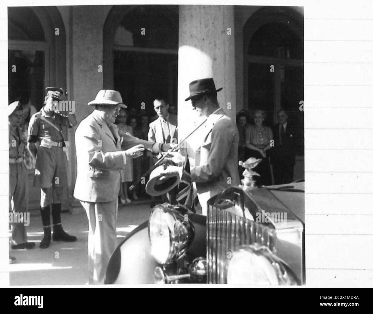 Il primo Ministro Churchill incontra membri del governo italiano all'ambasciata, con un membro dello staff che gli consegna il bastone mentre parte. Foto Stock