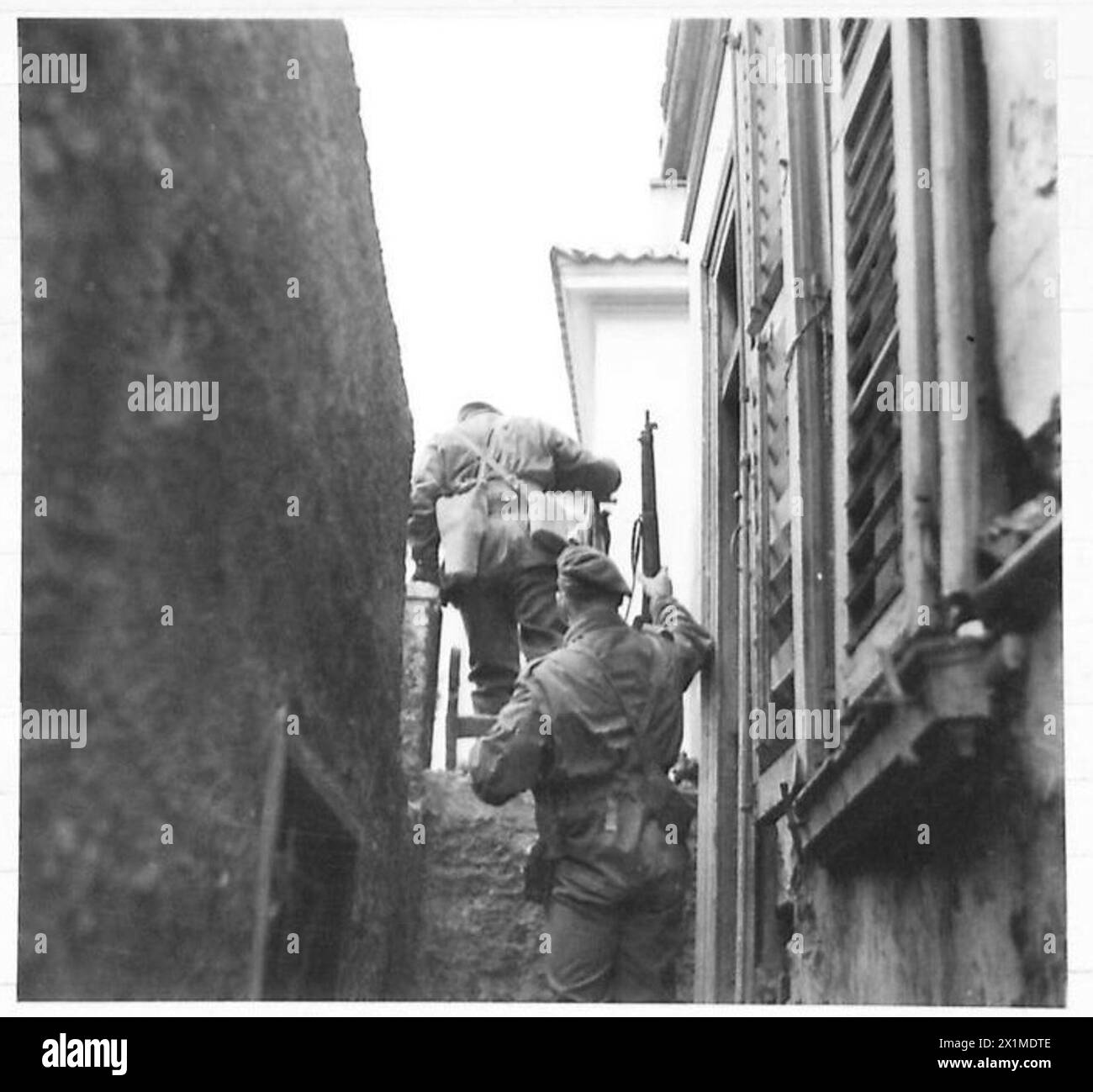 I paracadutisti impiegano tattiche sul tetto per sgombrare un blocco a sud di Metaxouriyon, incontrando il fuoco di mortai a lungo raggio da parte delle truppe E.L.A.S. il 31 dicembre 1944, British Army. Foto Stock