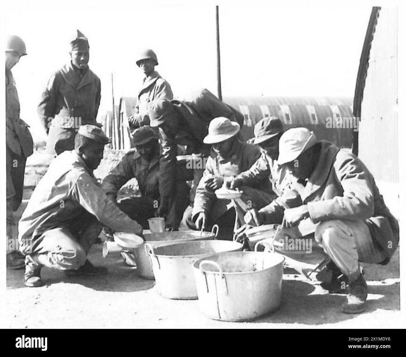 I soldati neri americani ricevono e prelevano le loro razioni a mezzogiorno in un deposito di rifornimenti generali per i negozi e le attrezzature americani, British Army. Foto Stock