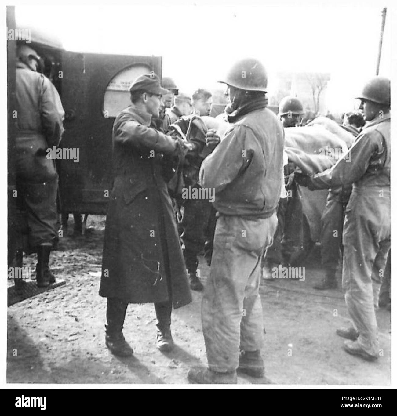 Un soldato tedesco ferito viene assistito in un'ambulanza da personale di ambulanza americano e tedesco durante la seconda guerra mondiale, illustrando l'evacuazione medica sul campo di battaglia in più teatri europei. Foto Stock
