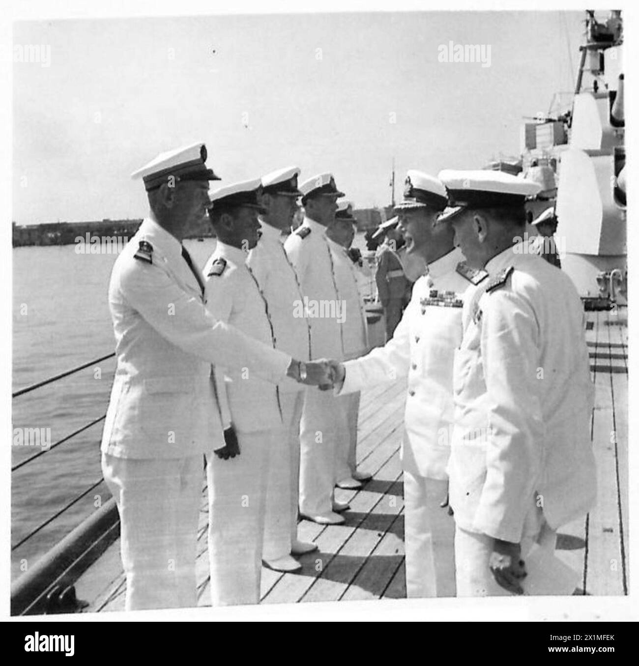 Il re incontra un ufficiale di marina francese a bordo della HMS Orion durante una visita in Italia. Foto Stock