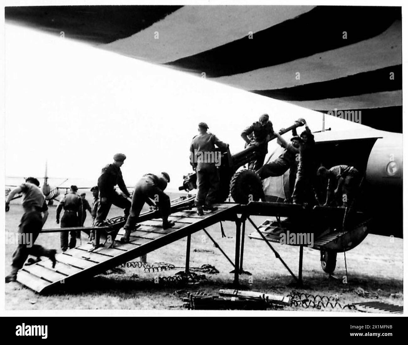 Forze aviotrasportate che caricano alianti con jeep e cannoni anticarro da 6 libbre su una rampa di carico in preparazione di un'invasione, British Army, 6th Airborne Division. Foto Stock