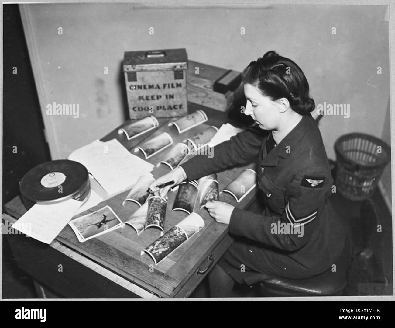 Il caporale Gunn assiste il sergente Mounteney nel garantire che le foto siano stampate e spedite prontamente ai comandi del Ministero dell'aria e della RAF, dimostrando il lavoro dei tecnici della W.A.F. nell'unità di produzione cinematografica. Foto Stock