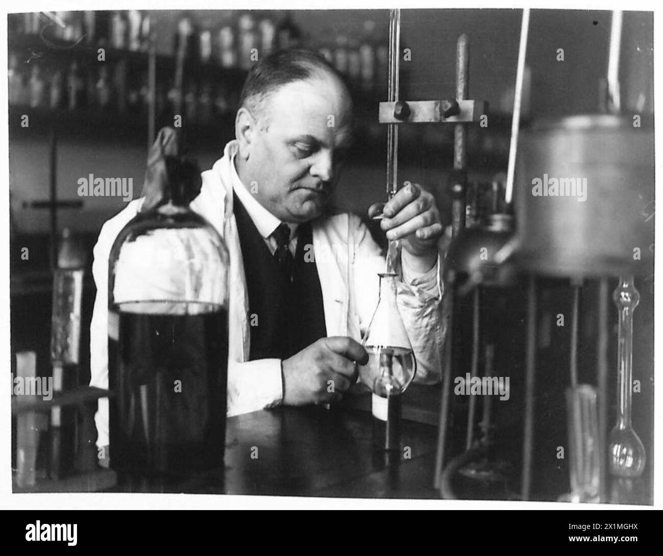 Il Dr. Sanderlands testa campioni di olio raffinato in un laboratorio per garantire la qualità e il corretto funzionamento dell'impianto di raffinazione del petrolio dell'esercito, British Army. Foto Stock