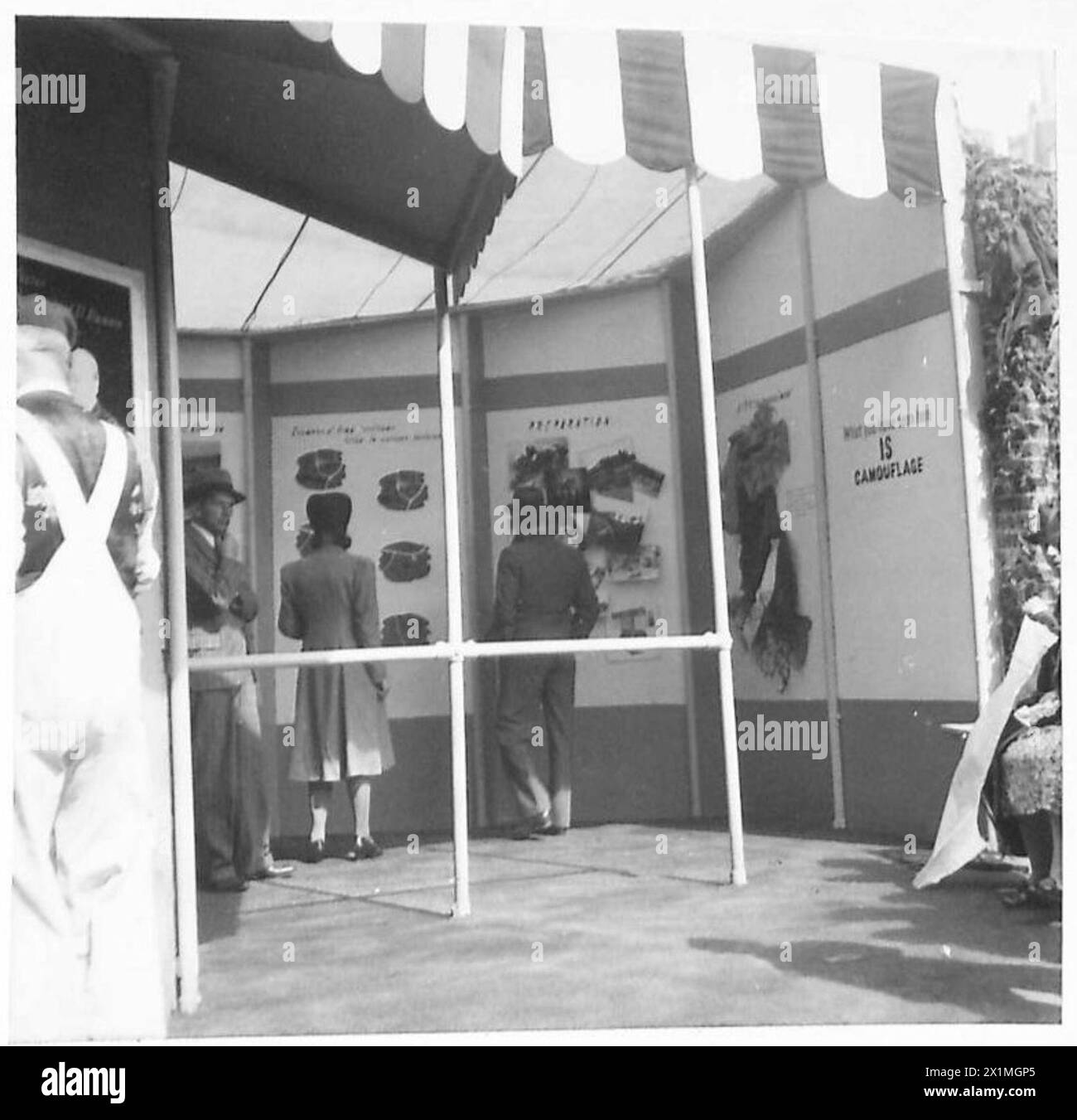 Visitatori che osservano la sezione delle attrezzature mimetiche in una mostra dell'esercito, British Army. Foto Stock