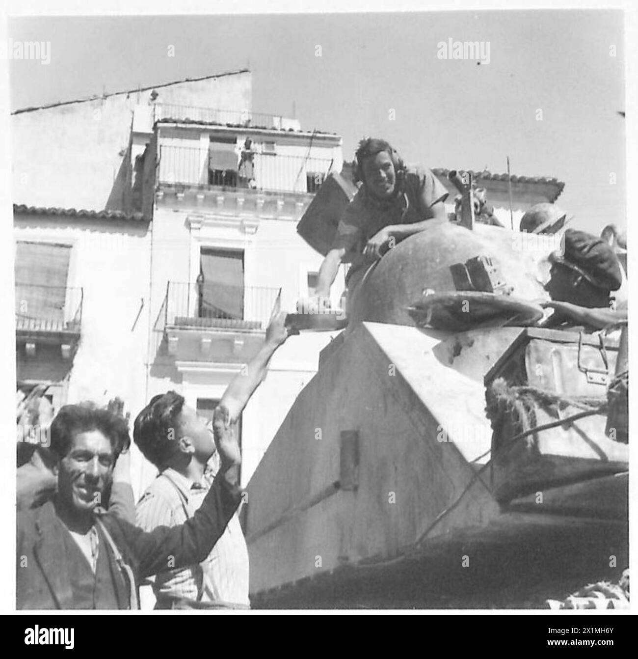 Un popolo di città consegna arance a un soldato del reggimento di carri armati durante la battaglia per Francofonte in Sicilia, British Army. Foto Stock