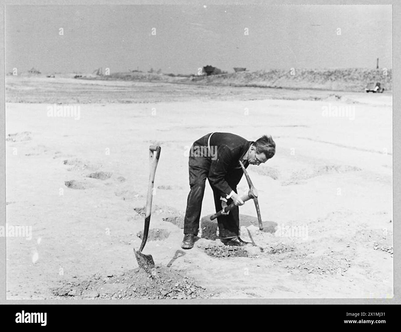 Il signor Gimes scava un tempio pre-romano sulla base di un nuovo campo d'aviazione della RAF nel 1944. Fotografia in bianco e nero che documenta la scoperta archeologica in terra militare. Foto Stock