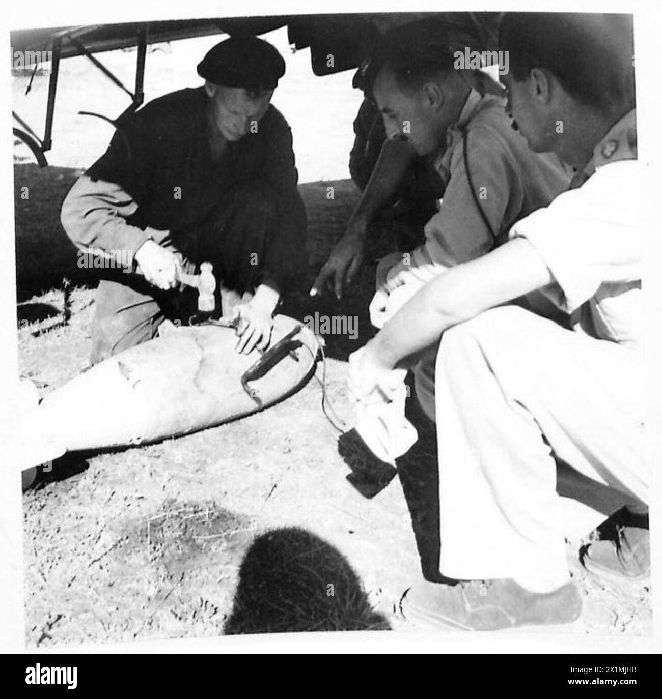 I fanti dell'Ottava Armata osservano la loro artiglieria volante mentre gli ingegneri caricano bombe ad azione ritardata da 250 libbre e bombe da 40 libbre sotto l'aereo mentre gli artifici regolano le micce, British Army. Foto Stock