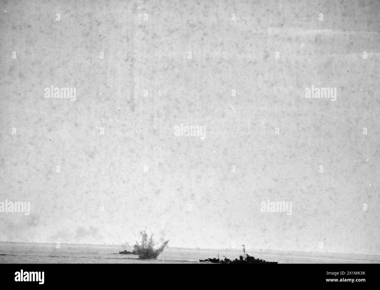 La HMS Warspite bombarda le posizioni nemiche a Catania, in Sicilia, il 17 luglio 1943, mentre i cacciatorpediniere attaccano un sottomarino con cariche di profondità, supportando le operazioni dell'esercito. Foto Stock