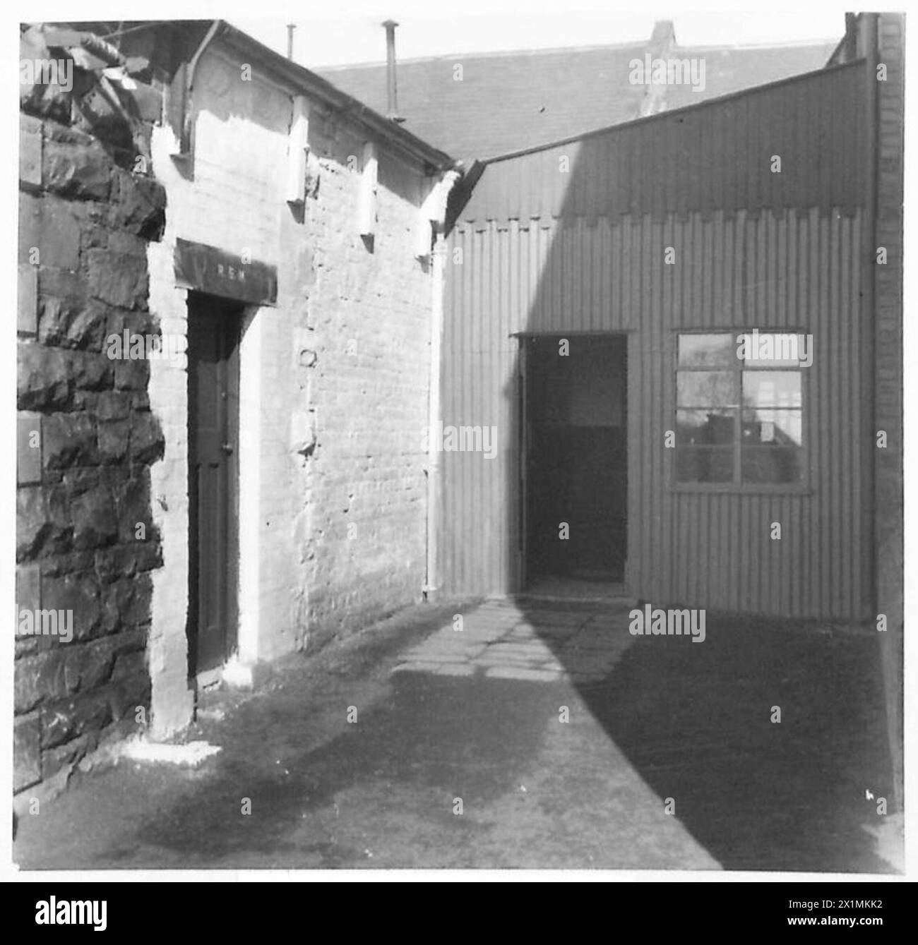 La caserma di detenzione militare di Carrickfergus, situata presso Hall Gate, è raffigurata in una fotografia in tempo di guerra. La struttura, costruita in ferro ondulato, servì come struttura di detenzione per i soldati durante la seconda guerra mondiale. L'immagine fornisce informazioni sulla progettazione utilitaristica e sui metodi di costruzione utilizzati per le infrastrutture militari durante il periodo. Foto Stock