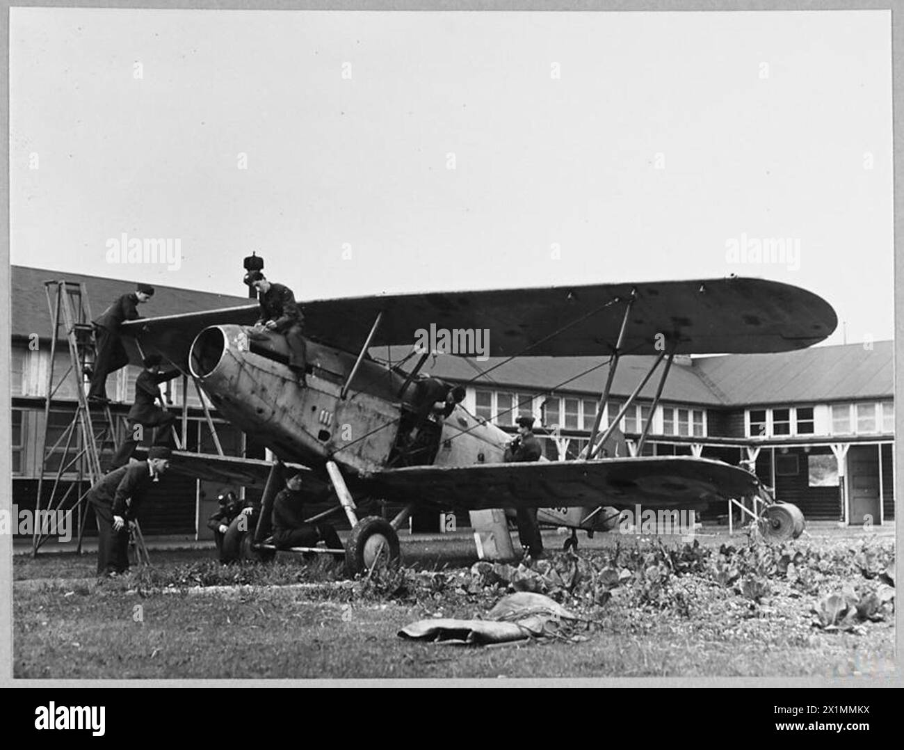 I CADETTI dell'A.T.C. RICOSTRUISCONO AEREI DIDATTICI - cadetti del No.1051 Dartford Borough Squadron A.T.C. hanno appena riparato un aereo didattico - un obsoleto Hawker Hind, che era atterrato con parti fabbricate con strani pezzi di rottami, tra cui pezzi di un vecchio letto. I cadetti al lavoro riparavano l'Hawker 'Hind' che era stato consegnato allo squadrone per l'addestramento a terra. [Foto emessa nel 1942] , Royal Air Force Foto Stock