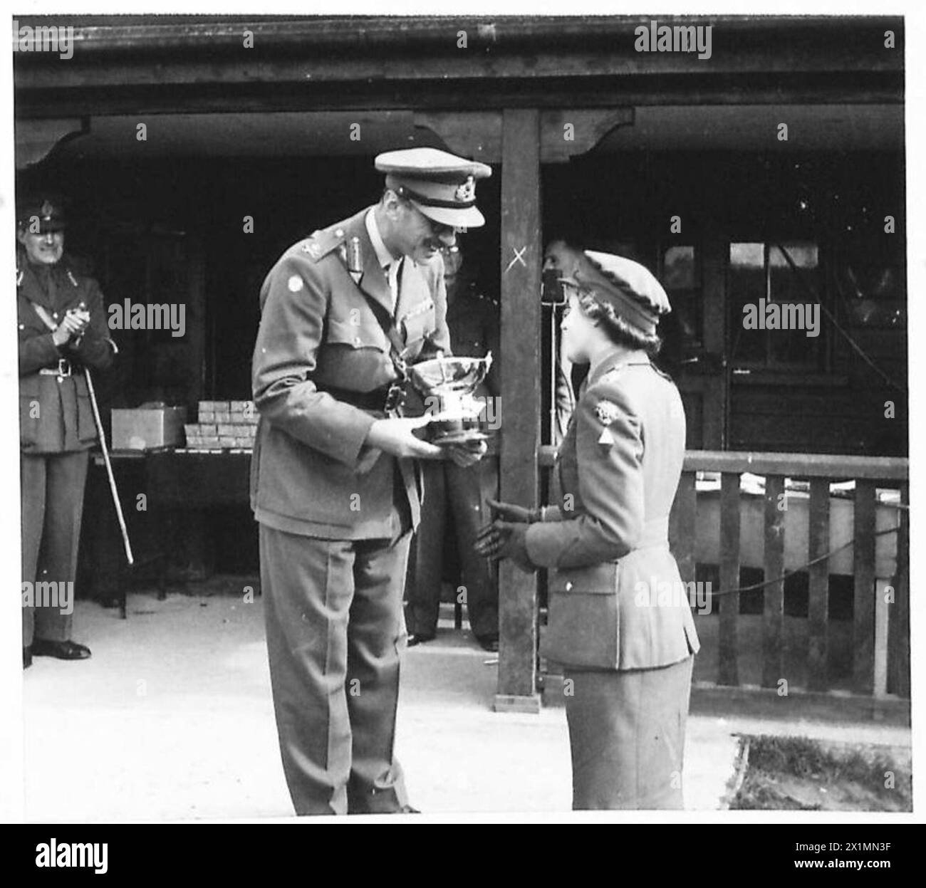 Il tenente generale J.G. des R. Swayne presenta la ciotola argentata a Sub. C.K. Clark della squadra vincitrice del concorso ATS Garden, British Army. Foto Stock