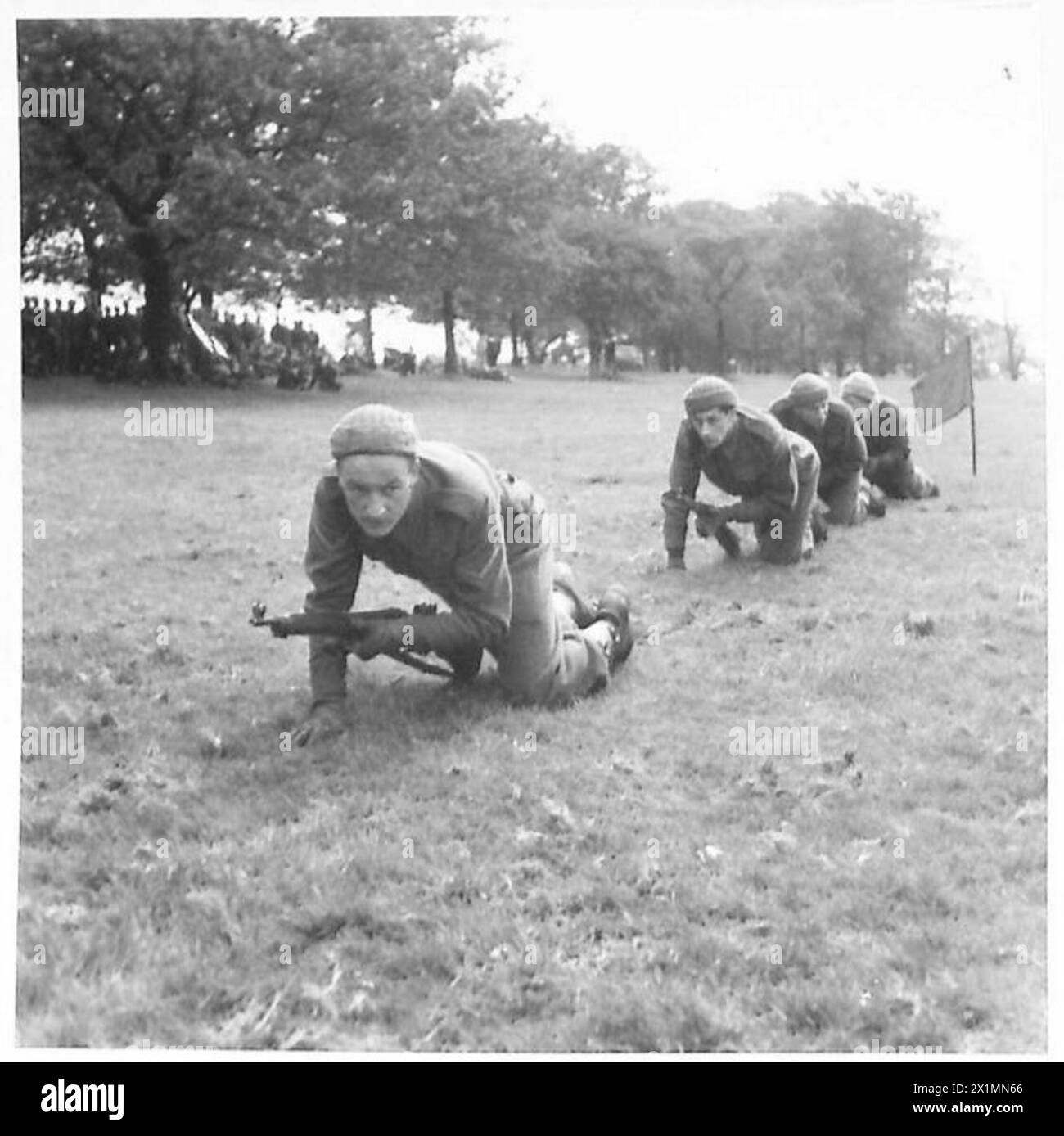 I Royal Electrical and Mechanical Engineers dimostrano a un plotone della Home Guard come un cecchino trasporta un fucile in una posizione di ricognizione, luglio 1942, British Army. Foto Stock