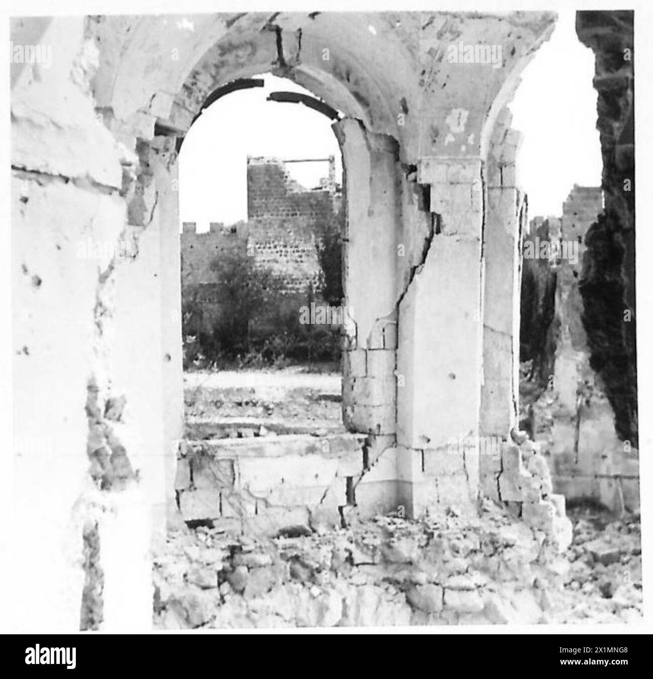 Il cortile di un castello parzialmente distrutto contiene detriti e un prato verde, mentre il personale dell'esercito britannico supervisiona il recupero di tesori artistici. Foto Stock