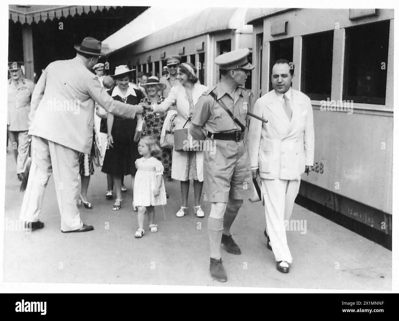 IL RE DI GRECIA CHE LASCIA IL CAIRO - H.M. il re di Grecia con il ministro della guerra greco, il signor Dimitrakakis, che cammina fino alla loro carrozza alla stazione. Dietro sua Maesta' c'e' la Principessa Katherin di Grecia, che stringe la mano a Sir Miles Lampson, e la bambina e' la Principessa Sophie, figlia del Principe ereditario, Esercito britannico Foto Stock