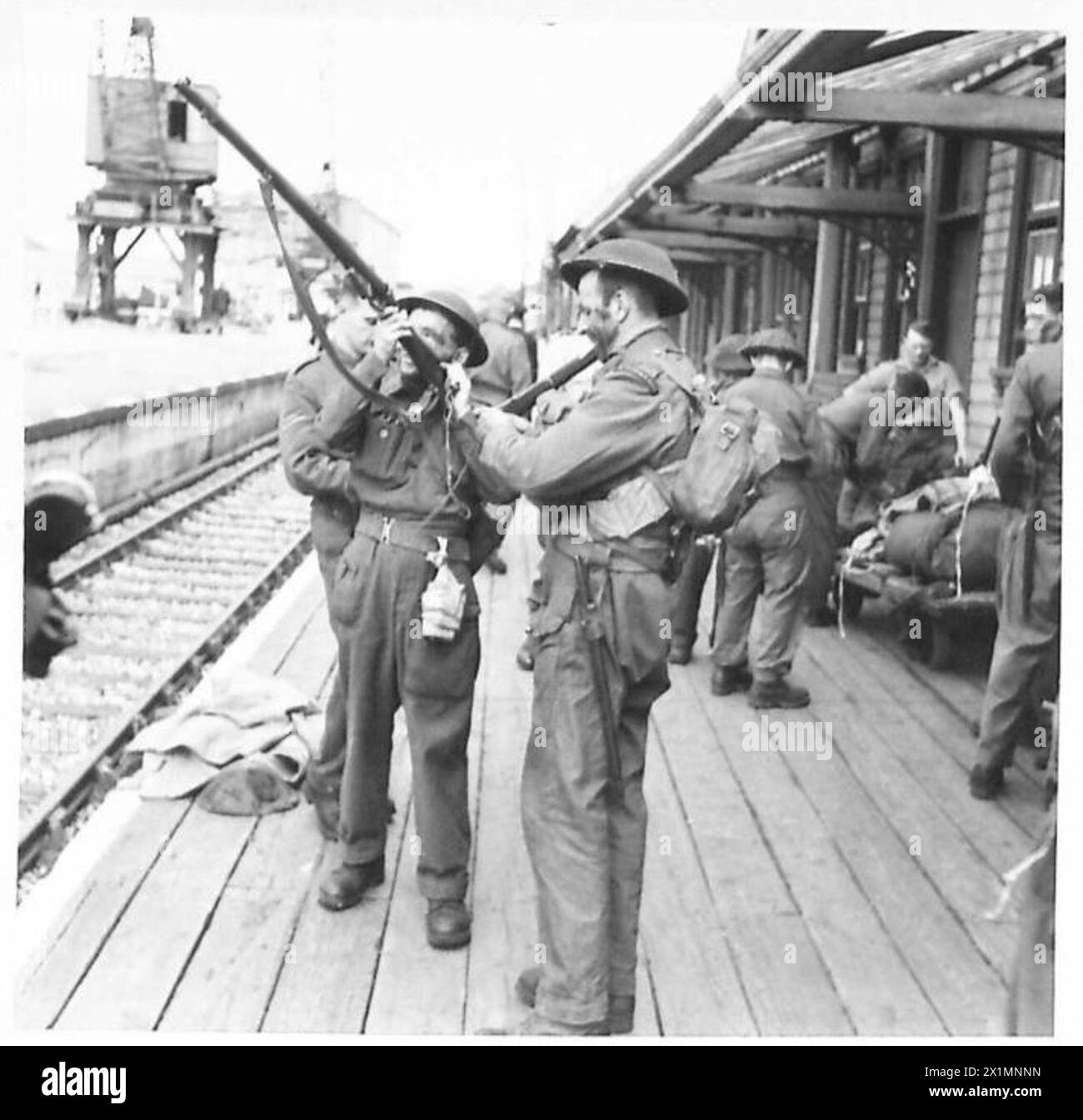 ARRIVO DA DIEPPE - questi uomini guardano i loro fucili e le loro attrezzature all'arrivo a Newhaven, British Army Foto Stock