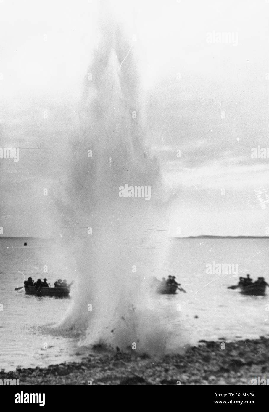 Un guscio esplode vicino alle barche a remi utilizzate dalla 1st Polish Independent Commando Company durante gli esercizi di addestramento in Scozia. Foto Stock