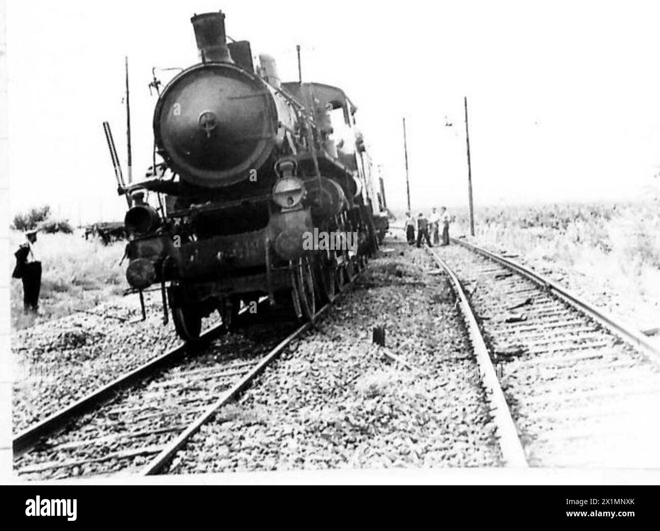 Il personale dell'Eighth Army utilizza un motore ferroviario recuperato, soprannominato "One Lung Lizzie", che gira su un cilindro, per i lavori di ricostruzione locali. Foto Stock