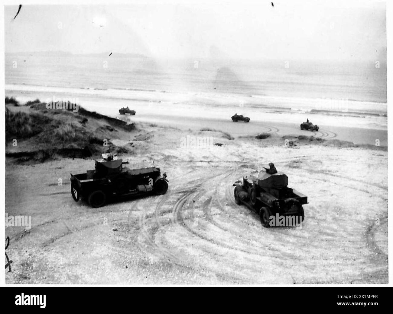 Le auto blindate dell'esercito britannico pattugliano lungo la costa dell'Irlanda del Nord. Foto Stock