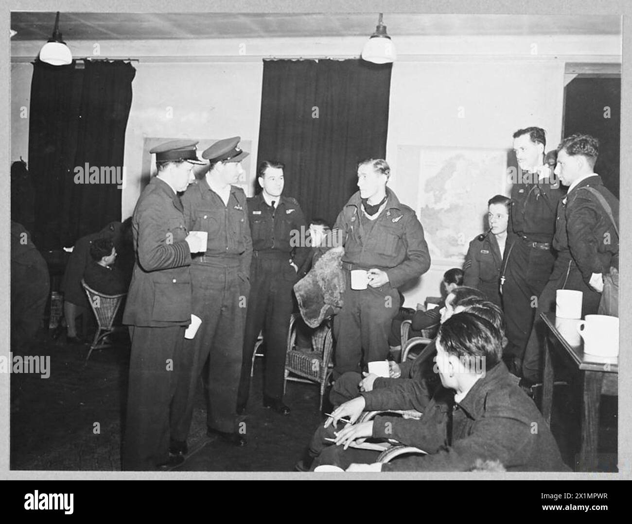 I bombardieri Lancaster con base in una stazione del Bomber Command della RAF parteciparono al raid pesante su Milano il 14-15 febbraio 1943; il personale viene ritratto dopo l'interrogatorio. Foto Stock