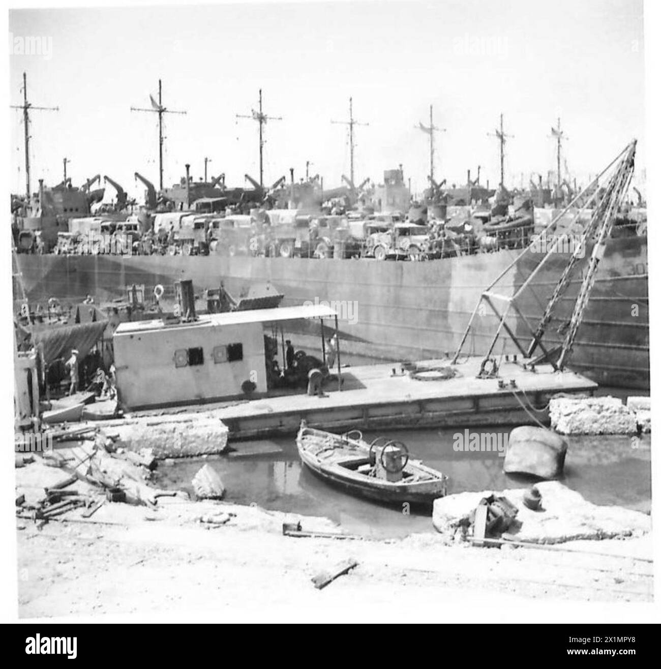 Personale dell'esercito britannico che carica mezzi da sbarco nel porto danneggiato di Sousse. Foto Stock