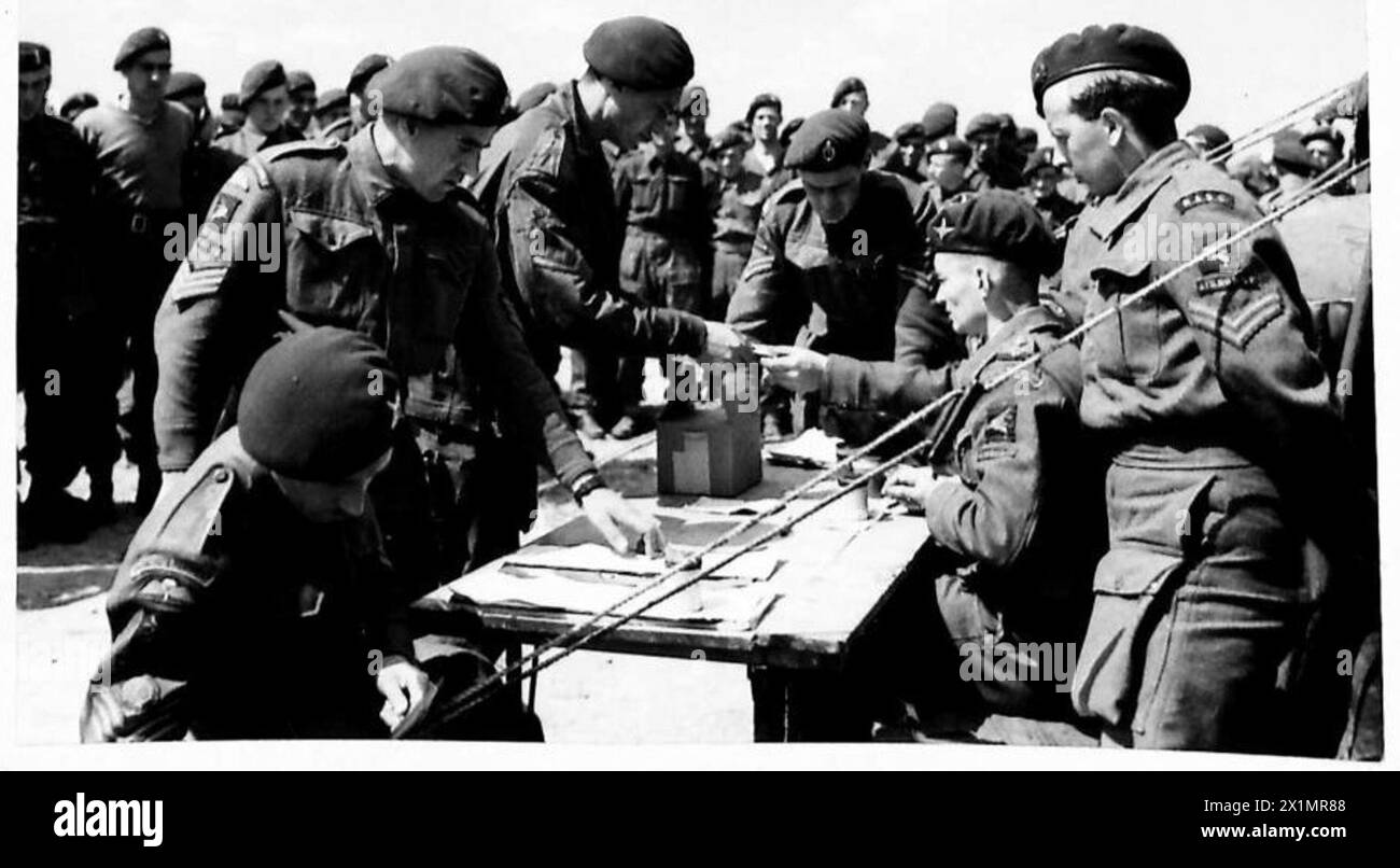 Il personale della 6th Airborne Division dell'esercito britannico riceve la prima paga in valuta francese durante una parata salariale in preparazione di un'invasione militare. Foto Stock