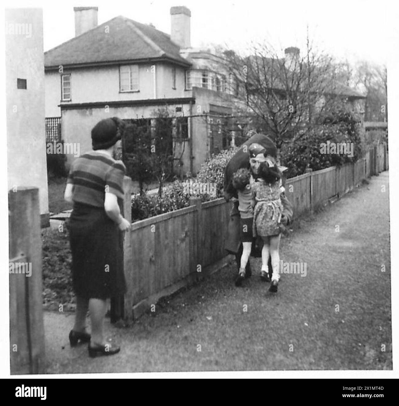L/Bdr. J.P. Grundy dell'Eighth Army torna a casa dal suo reggimento e viene accolto dai suoi due figli, British Army. Foto Stock