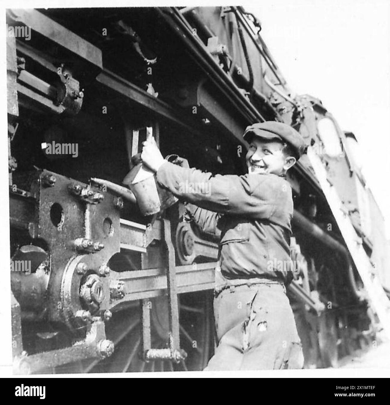 Il diciassettenne Zivarod Rajkovic olia le ruote di un motore ferroviario alla stazione ferroviaria di Belgrado-Cosmopolitan in Jugoslavia, sotto la supervisione dell'esercito britannico. Foto Stock