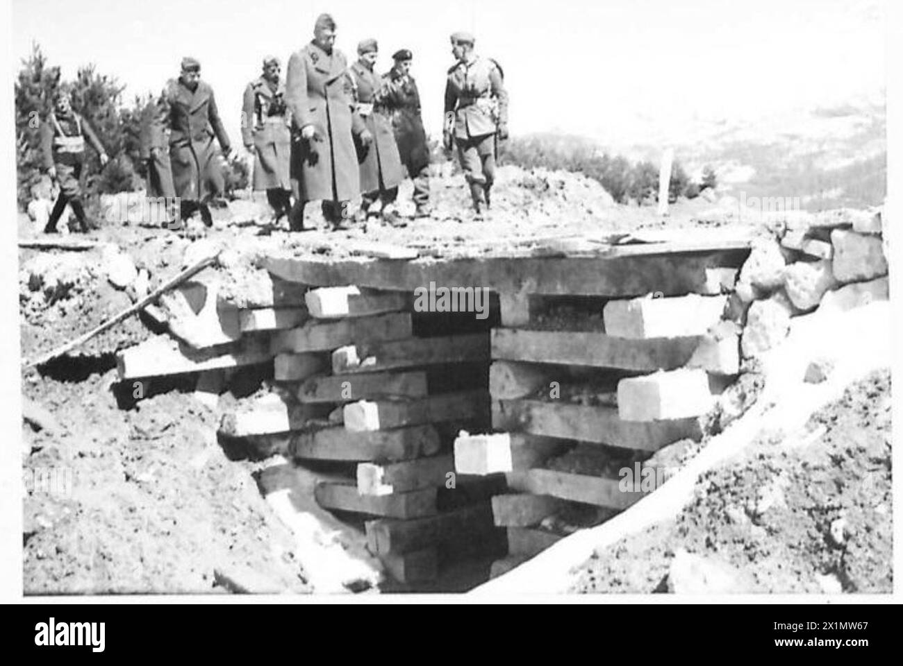 Il generale Kazimierz Sosnkowski e il suo gruppo attraversano un ponte temporaneo su un cratere esplosivo fuori San Pietro Avellana mentre visitano le unità della 3a Divisione fucilieri dei Carpazi, il 28-29 marzo 1944. Foto Stock