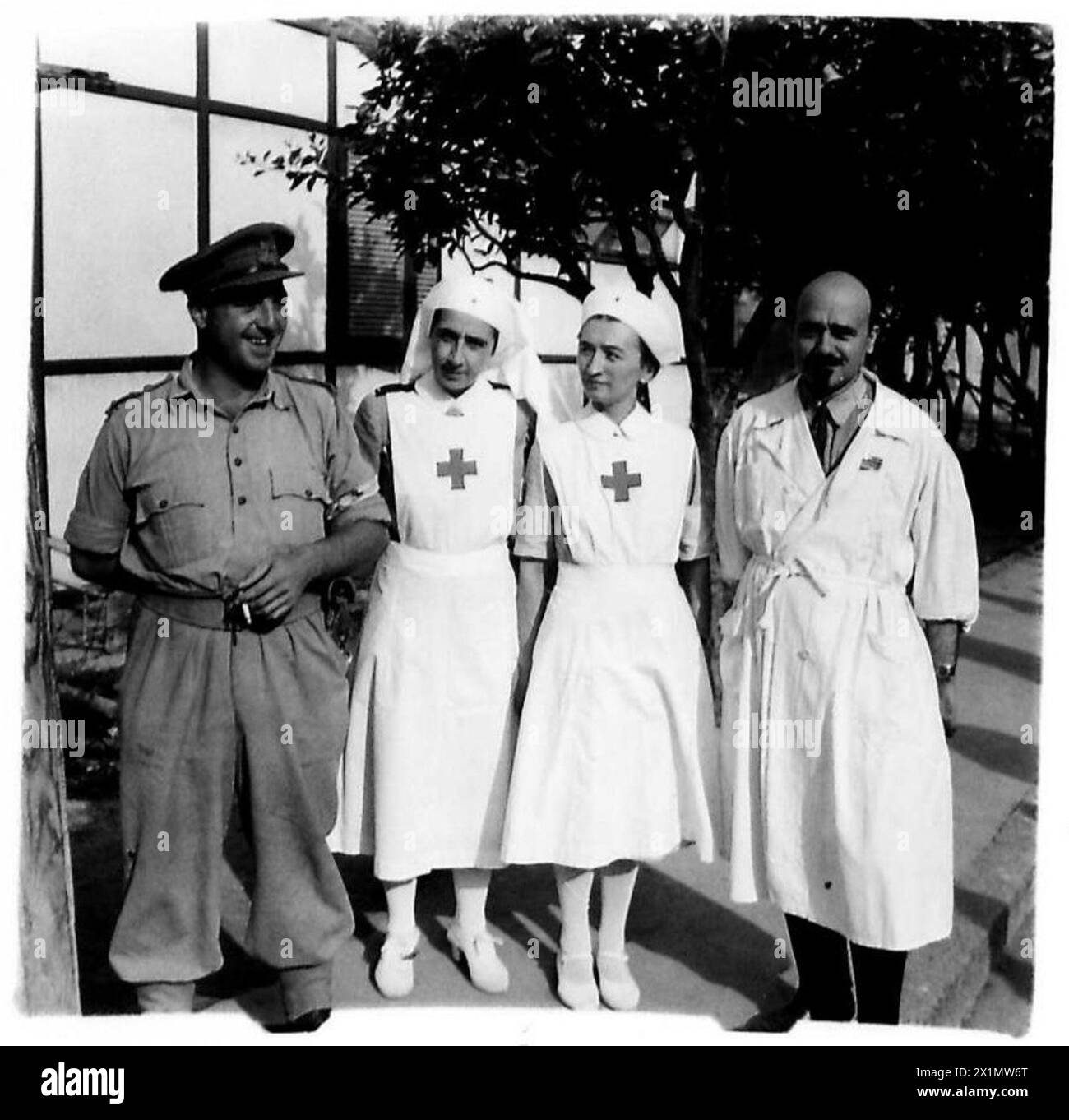 Il capitano Wiseman della RAMC e due Sorelle con un capitano del corpo medico italiano forniscono assistenza ai prigionieri sul fronte della Quinta Armata in Italia, British Army. Foto Stock