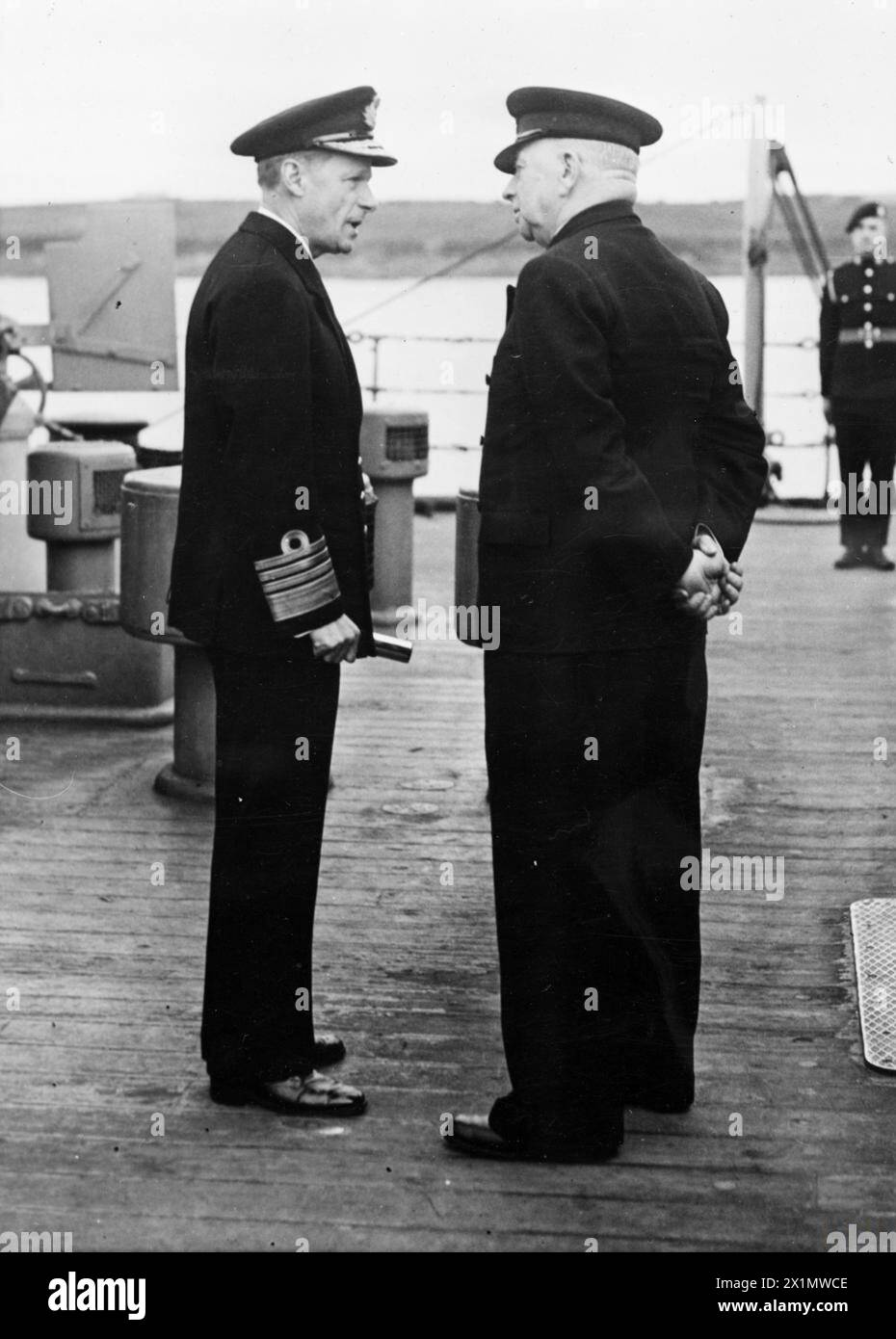 Il primo Lord dell'Ammiragliato, A.V. Alexander, visita la Home Fleet a Scapa Flow l'11 maggio 1945 per aprire la catena di strade di barriera che proteggono l'ancoraggio dagli attacchi degli U-Boot, parlando con l'ammiraglio Sir Henry Moore sulla HMS Rodney. Foto Stock