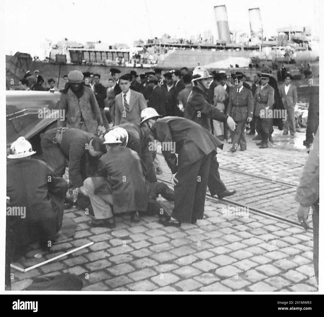 Una squadra di soccorso francese fornisce il primo soccorso a un soldato americano dopo che un carro armato Grant è caduto in acqua durante lo scarico presso i moli di Algeri occupati dagli Alleati il 17 novembre 1942. Due membri dell'equipaggio nuotarono a riva; un sommergibile francese salvò il terzo, salvandogli la vita dopo le cure. Foto Stock