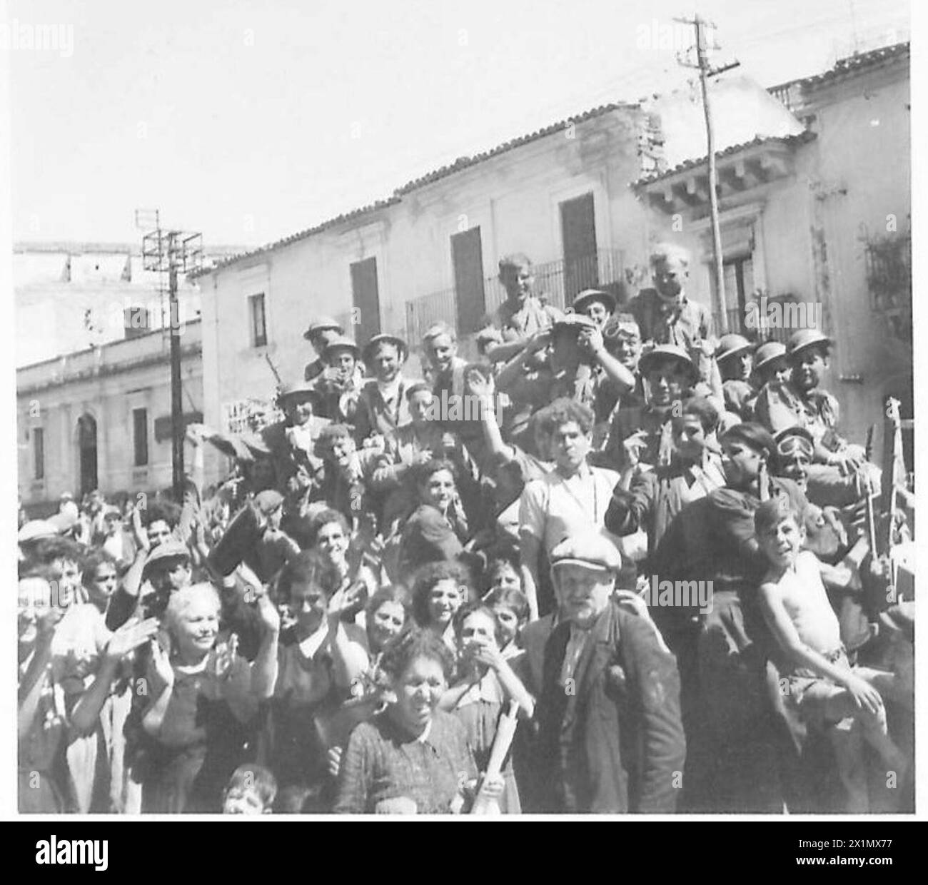 BATTAGLIA DI SICILIA BATTAGLIA PER FRANCOFONTE - Una folla di persone che applaudiscono gli uomini del 5/7° Gordon Highlanders mentre attraversano la città, l'esercito britannico Foto Stock