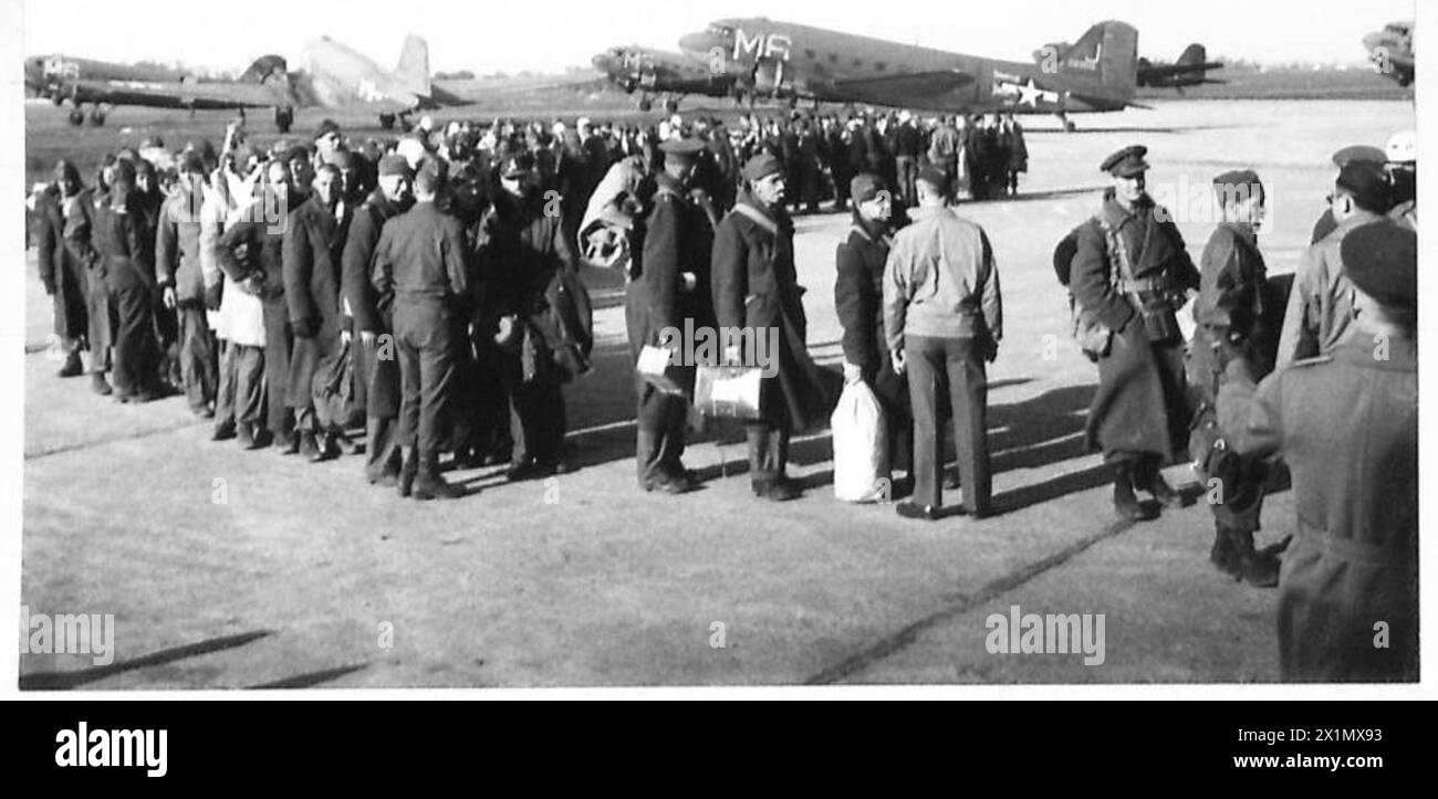 PRIGIONIERI OFLAG RILASCIATI DALLE TRUPPE AMERICANE - prigionieri britannici in attesa di essere trasportati a casa a le Havre. Sullo sfondo ci sono aerei da trasporto americani, British Army, 21st Army Group Foto Stock