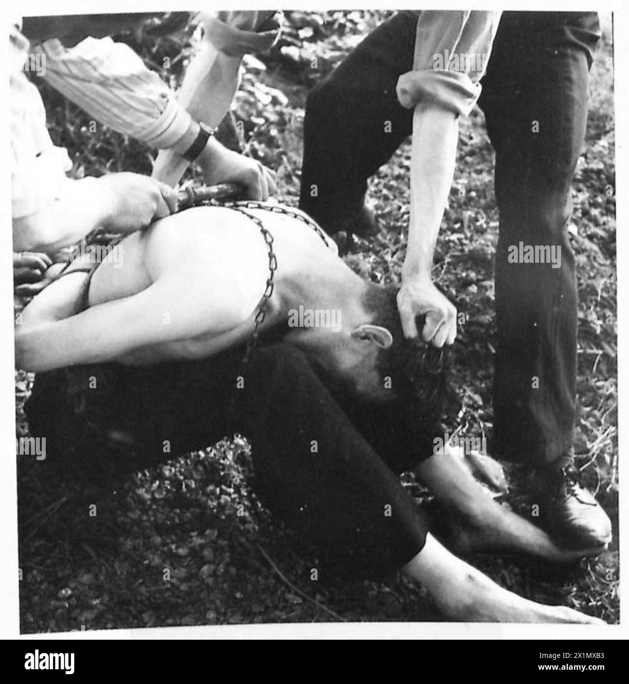 La Gestapo torturò i civili belgi legandoli in catene e stringendoli con un bastone. I rapporti dell'esercito britannico documentarono queste atrocità durante la seconda guerra mondiale sotto il 21st Army Group. Foto Stock